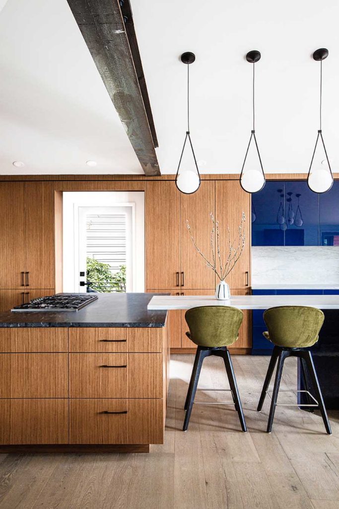 Redesigned kitchen with bold blue lacquer accent cabinets and a mix earthiness of rift-cut teak cabinetry.