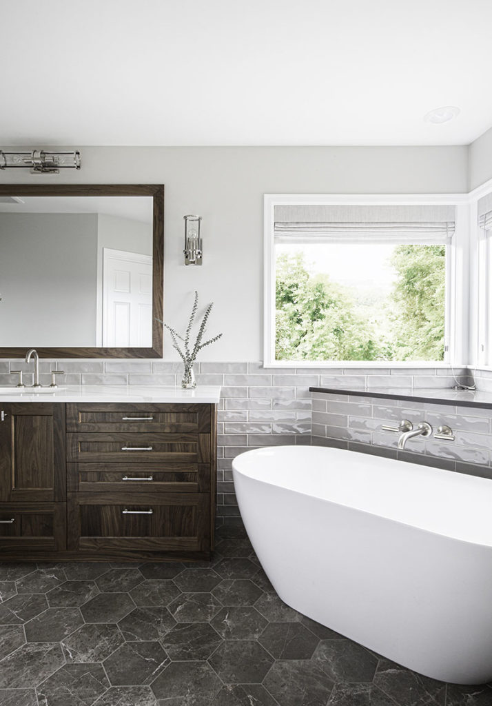 Architectural design Bellevue bathroom with soaking tub, dark grey hex tile floor, walnut cabinets, and quartz countertop.