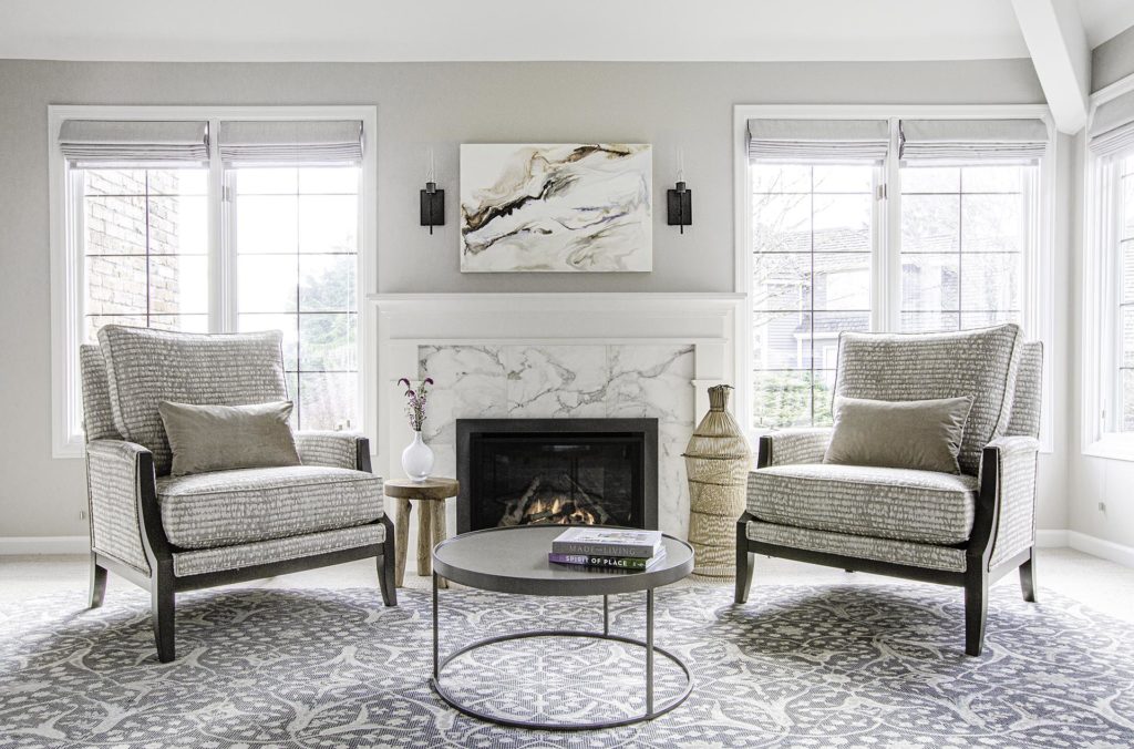Renovated traditional style living room with marble fireplace, Corrie LaVelle encaustic art above mantel and relaxing chairs