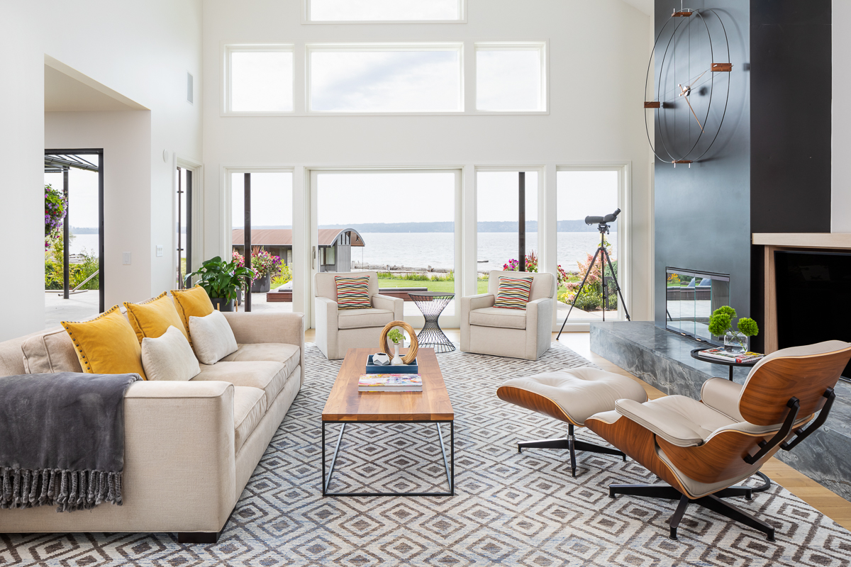 Lakefront living room with panoramic windows — luxury home design and waterfront architecture